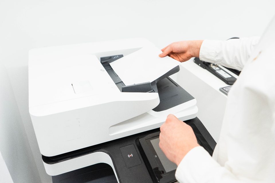 Person scanning a document on a multifunction printer and scanner