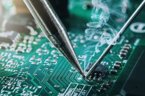 Close-up of component-level soldering repair on a circuit board