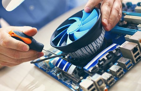 Technician installing a CPU cooling fan during a computer hardware upgrade